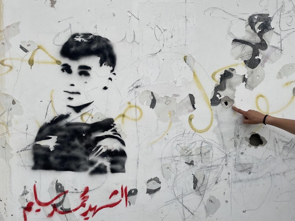 A graffito of Mohammed al-Sleem on the wall of a school he ran past while fleeing from Israeli soldiers who fatally shot him in the back, May 5, 2023. Witnesses said automatic gunfire left 10 bullet impacts in the wall, near Azzun, in the West Bank. 