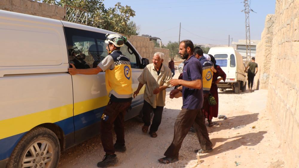Volunteers with the Syria Civil Defense assist three people, a child, his uncle and his aunt, who suffered injuries after a dud submunition exploded in front of their house on October 7, in the city of Termanin, Syria. 