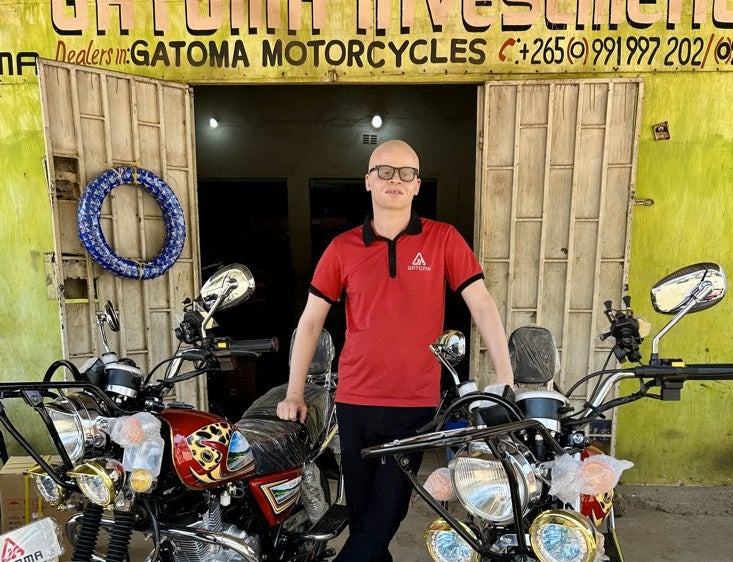 Ian Simbota, défenseur des droits des personnes handicapées au Malawi et ex-président de l'Association des personnes atteintes d'albinisme au Malawi (APAM), photographié dans le magasin de motos où il travaille comme chargé de marketing. 