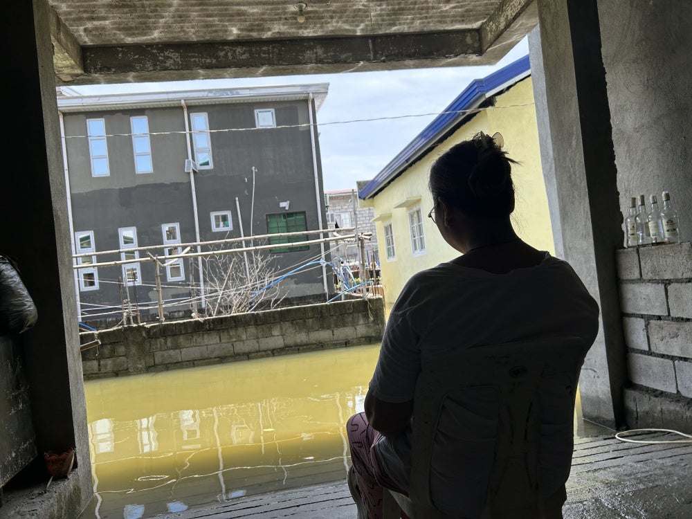 A resident looks out to water, her daily view in the Pulo relocation site, July 14, 2026.