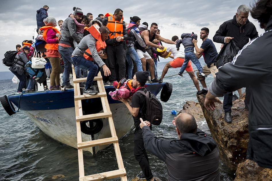 Asylum seekers and migrants descend from a large fishing vessel used to transport them from Turkey to the Greek island of Lesbos. October 11, 2015. 