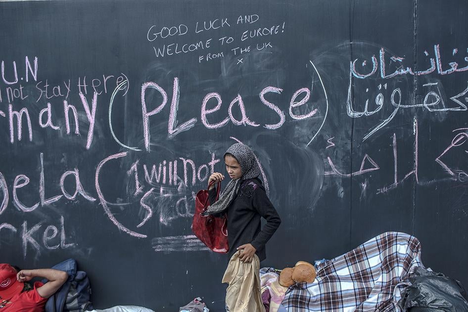 A young refugee girl walks past graffiti at the Keleti train station in Budapest, Hungary, on September 4, 2015. 