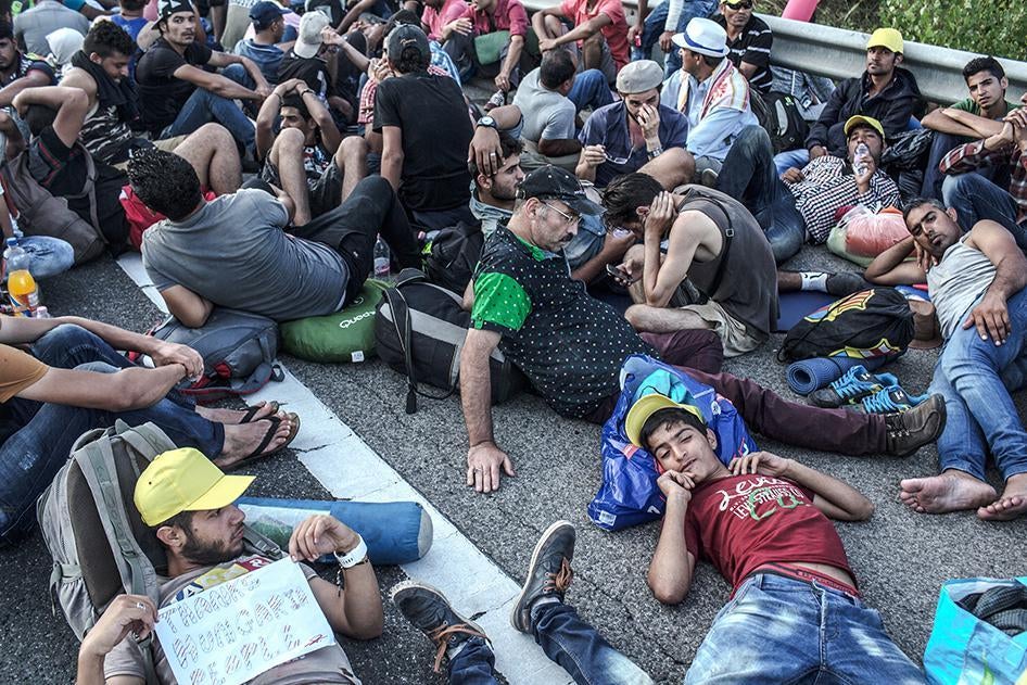 Refugees and asylum seekers rest on the Hungarian highway M1, near Budapest, during their march toward Vienna, Austria.  September 4, 2015.