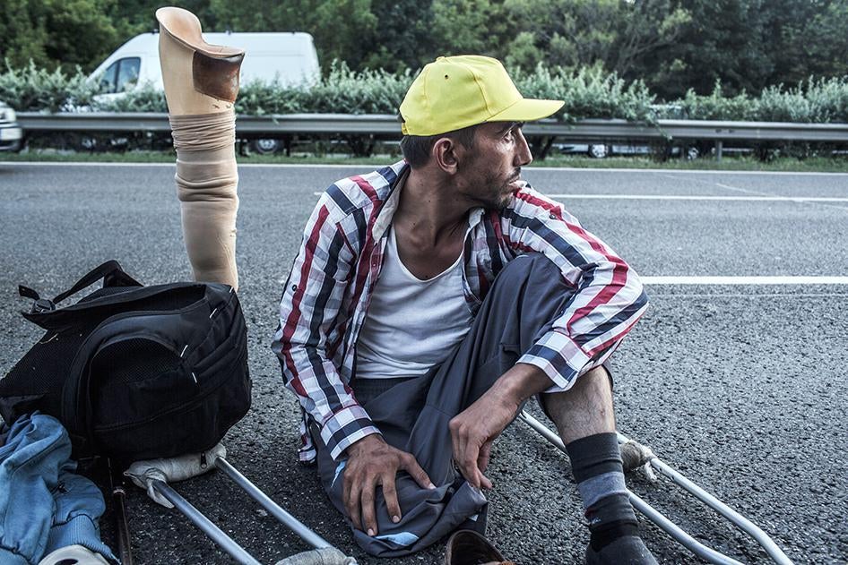 Safi, a 30-year-old Syrian refugee from Aleppo, rests during the walk from Budapest toward Vienna, on highway M1 near Budapest, Hungary on Sept. 4, 2015.