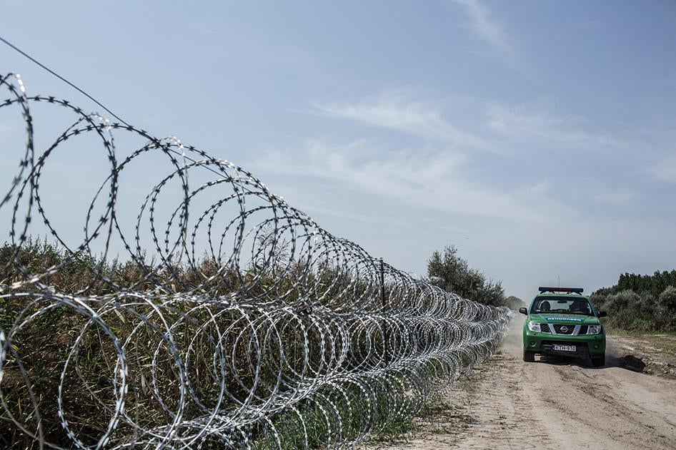 Hungarian police patrol the border with Serbia in Röszke, Hungary. The Hungarian government put up the razor-wire fence in an effort to stem the flow of refugees and migrants into Hungary. September 3, 2015.
