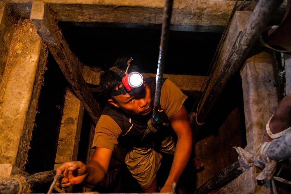 miner emerges from an underground pit