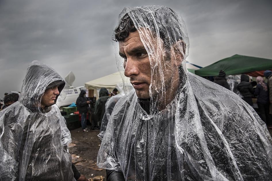 An asylum seeker from Afghanistan stands in the rain in Roszke, Hungary, near the border with Serbia. He said he was an army commander and fled his country because of death threats against him by the Taliban. September 10, 2015.