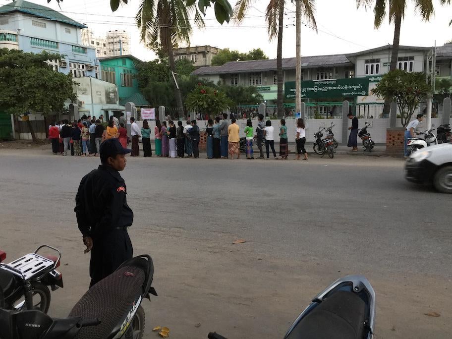 An unarmed security guard watches as polls open in Mandalay.