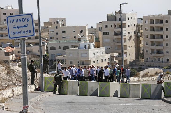 Des Palestiniens font la queue devant un point de contrôle dans le quartier d'Issawiya à Jérusalem-Est, le 16 octobre 2015, deux jours après l’installation par les autorités israéliennes d’un barrage routier à cet emplacement.