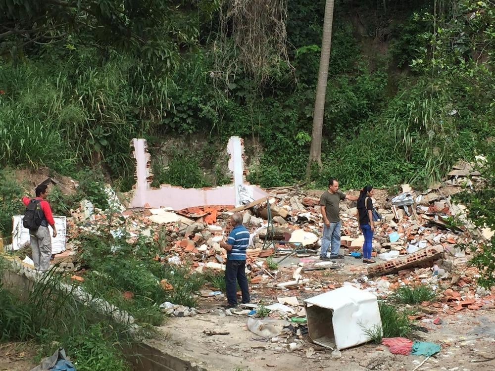 Residentes muestran los escombros que quedaron donde estaban sus casas que fueron demolidas a lo largo de la Carretera Panamericana en el estado de Miranda. 