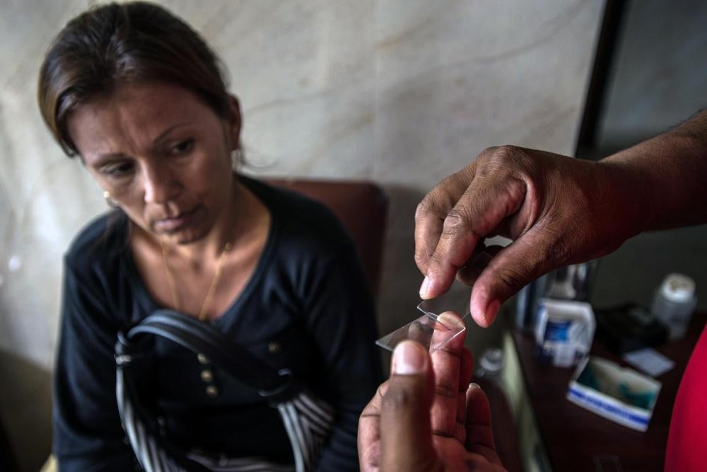Soraya Rodríguez se deja practicar una punción en la oreja durante un análisis de sangre para detectar malaria en una clínica en Tumerero, 25 de mayo de 2016. Más de 100.000 personas en Venezuela contrajeron malaria en 2015.