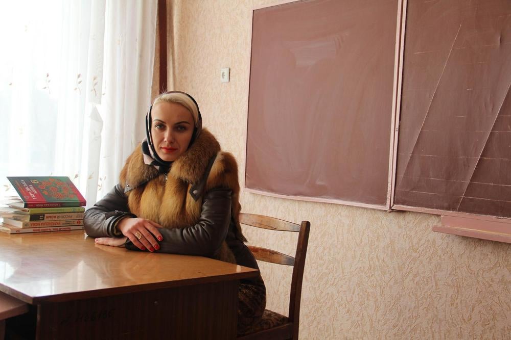 Ukrainian language teacher dressed in a thick coat in a classroom of School Number 2 in Marinka. Disruptions to the municipal gas system caused by the conflict have left many schools without sufficient heating to hold classes. 