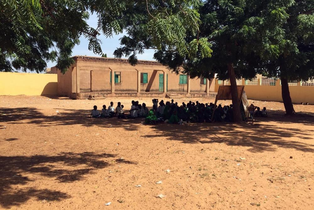 Des élèves assis sous des arbres à l’école primaire Nahuta à Potiskum dans l’État de Yobe, dans le nord-est du Nigeria. L’enseignement se fait à l’extérieur depuis que l’école a été en partie incendiée par Boko Haram en octobre 2012. 