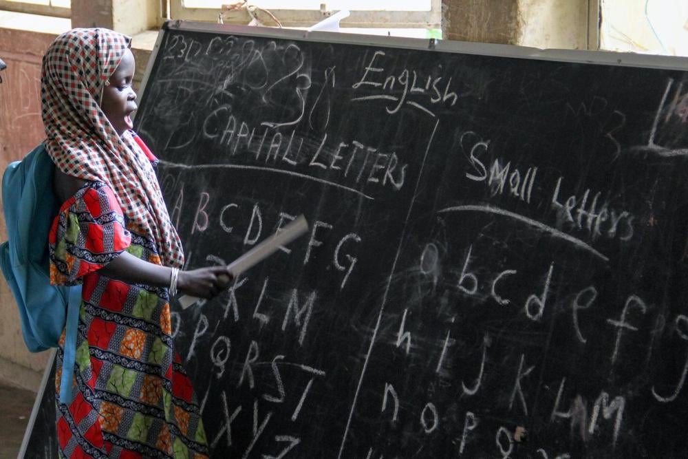 Une élève récite l’alphabet en septembre 2015, devant un tableau dans un camp de déplacés installé dans une école de Maiduguri dans l’État de Borno (Nigeria). 