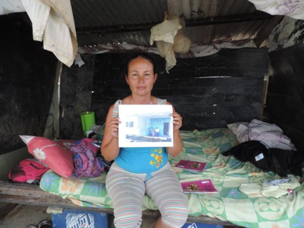Resident of the Brisas del Hipódromo community in Carabobo state shows a picture of her demolished home and where she lived after the demolition. © 2015 PROVEA