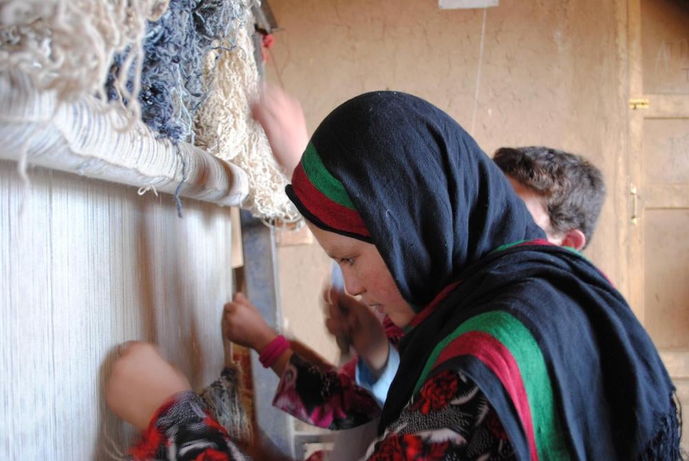 Marina, 15, works on a carpet loom at their home in Bamiyan province. Marina told Human Rights Watch that she coughs from inhaling wool dust. 