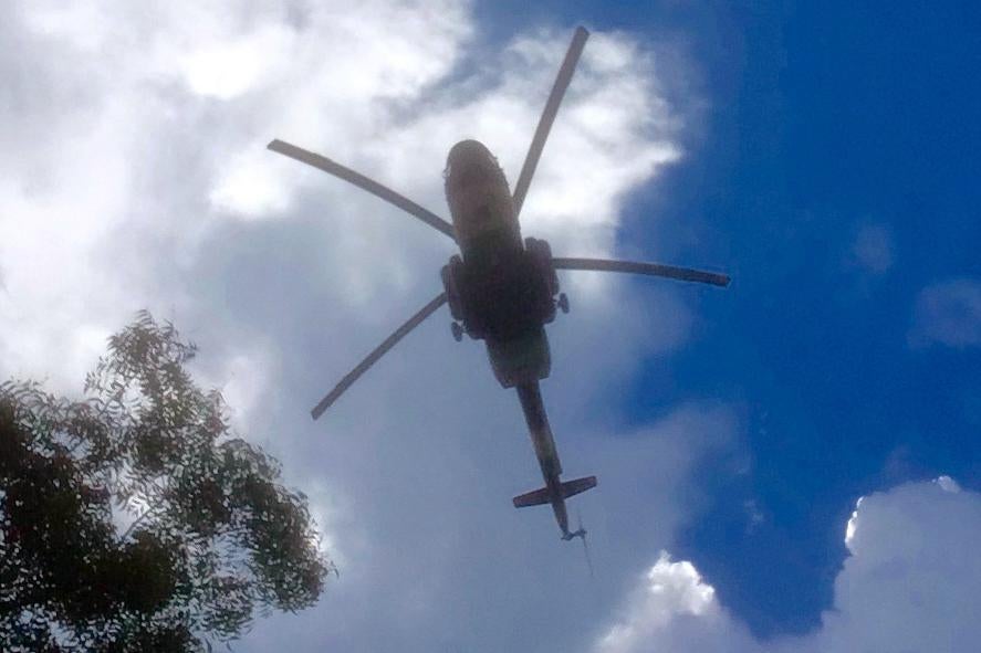Военный вертолет правительственных войск над лагерем вынужденных переселенцев у базы миссии ООН в Тонгпини, Джуба. 