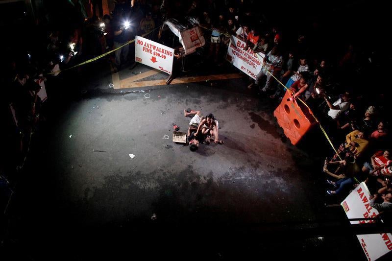 Jennelyn Olaires, 26, weeps over the body of her partner, who was killed on a street by a vigilante group, according to police, in a spate of drug related killings in Pasay city, Metro Manila, Philippines July 23, 2016. A sign on a cardboard found near th