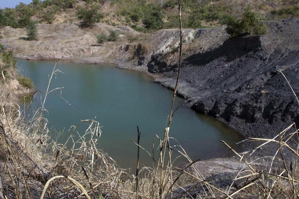 Un puits de mine à ciel ouvert rempli d’eau à la mine de charbon d’Eland à Mwabulambo, au Malawi. Après la fermeture en 2015, la société a laissé plusieurs puits à ciel ouvert, des piles de charbon et des trous profonds remplis d’eau. Selon le ministère d