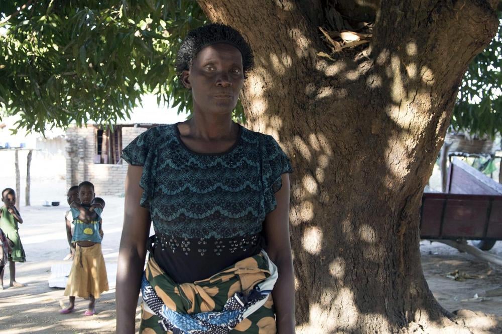 Rojaina N., under the tree that served as a shelter for her family and where she and her family lived for a couple of weeks after their relocation due to coal mining operations in Mwabulambo, Karonga district. 