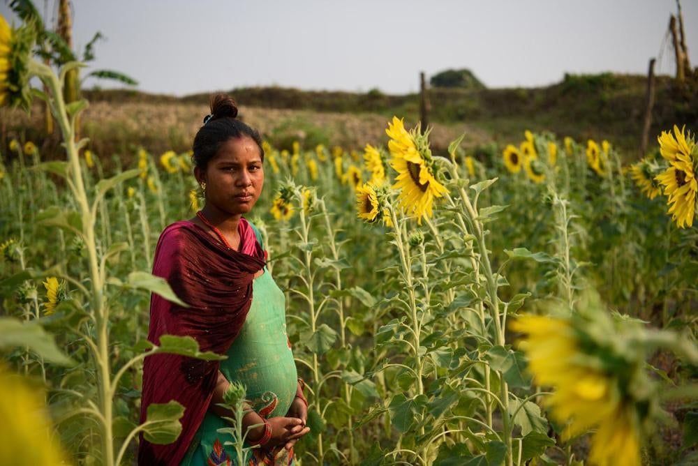 Sharmila G., une jeune Népalaise de 14 ans qui deux ans auparavant a épousé un jeune homme de 18 ans, photographiée dans un champ alors qu’elle était enceinte de sept mois. Elle regrette aujourd’hui de s’être mariée à l’âge de 12 ans, d’avoir dû quitter l