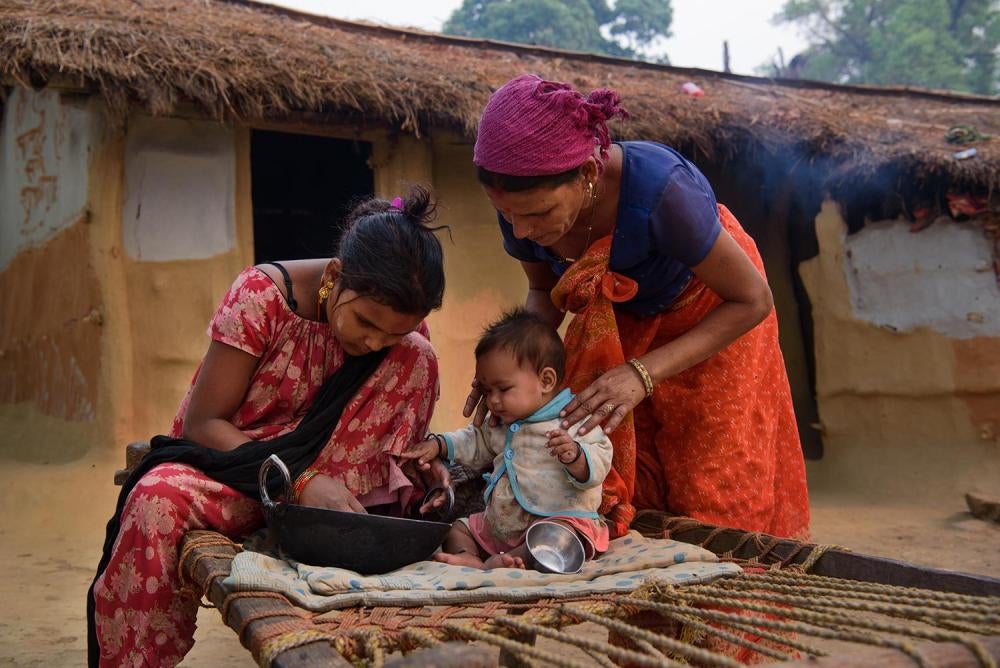 Lalita B., à gauche, une jeune Népalaise de 17 ans qui s’est mariée à 12 ans et dont le mari l’a par la suite abandonnée, photographiée avec sa fillette et sa mère devant leur domicle à Kailali. 25 avril 2016.