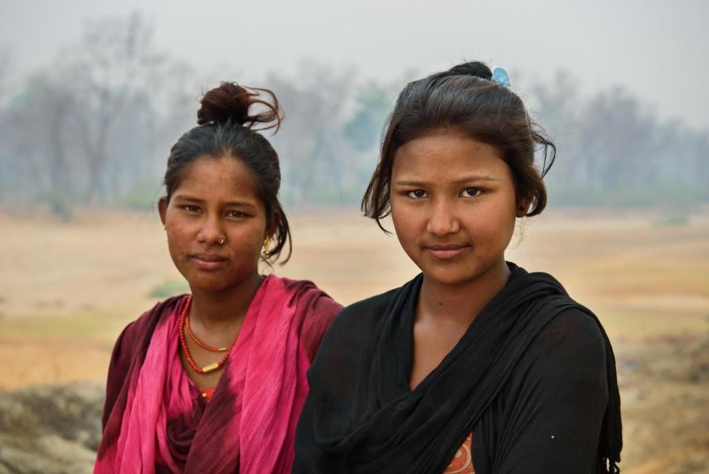 Sharmila G., 14, and Sharda D., 15, stand together in Kailali, Nepal. Sharda is still in school and does not want to marry, like many of the other girls in her community. Sharmila eloped and married at 12 and was seven months pregnant when this photograph