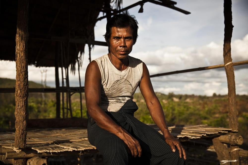 So Khai, sitting on the edge of thatched roof platform structure that he and other villagers built to serve as a school for children in Ahtet Kawyin village in Karen State. Villagers there have been regularly displaced by fighting in the area.