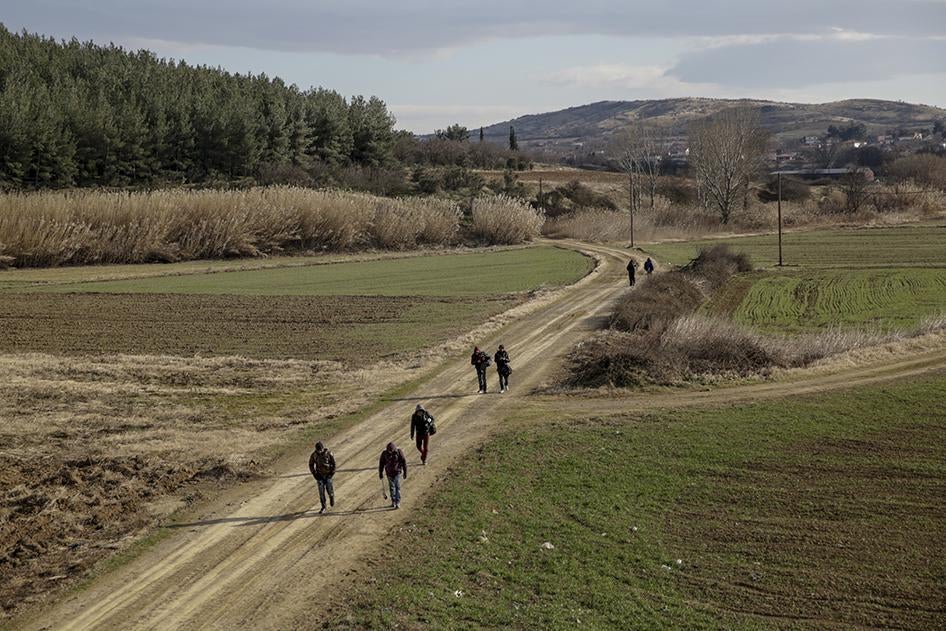 Asylum seekers from North Africa, Sri Lanka, and Iran walk along a rural path near the Idomeni border crossing in Greece, seeking to enter Macedonia by sneaking across the border fence.  January 26, 2016.