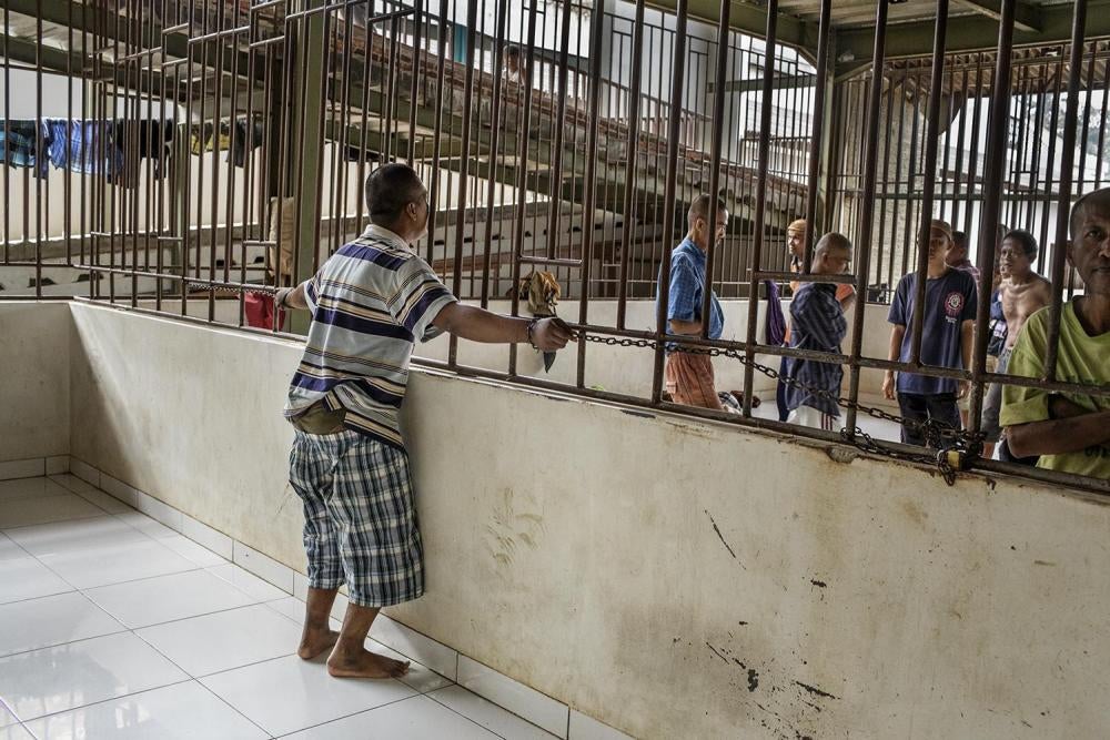 A man is restrained with chains in the male section of Galuh Rehabilitation Center in Bekasi.