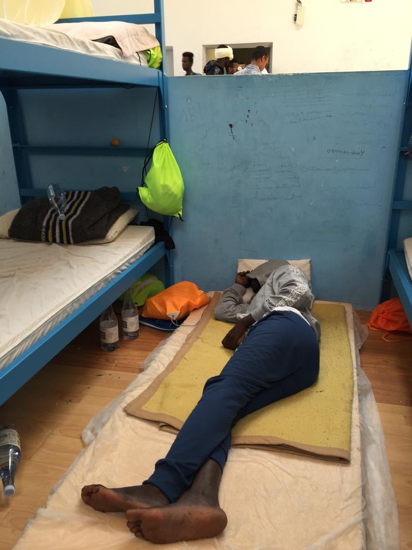 A man sleeps on the floor at the Pozzallo “hotspot,” where families, unaccompanied children, and adult men are sleeping next to each other.