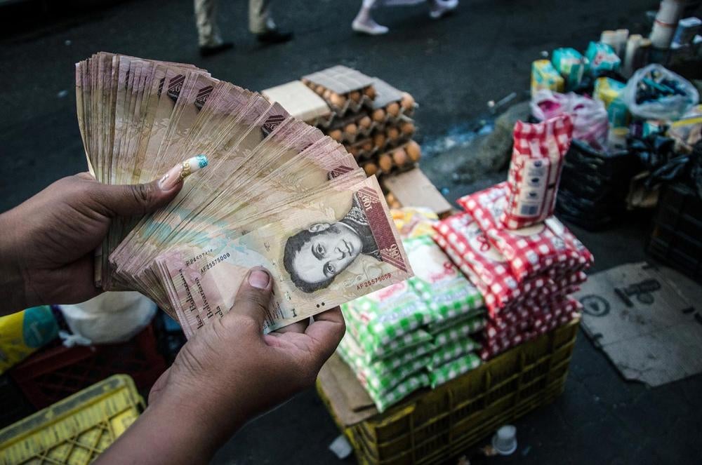 Una vendedora del mercado negro muestra el dinero que ganó ilegalmente con la reventa, a un valor muy superior, de productos con control de precios, en el barrio marginal de Petare en las afueras de Caracas, 14 de enero de 2016. 