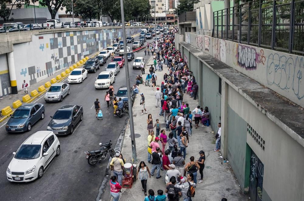 Muchísimas personas hacen fila para comprar artículos con escasez, como azúcar, aceite para cocinar, leche, arroz, papel higiénico y pañales para bebés, sujetos a control de precios, durante un evento gubernamental en Caracas, 24 de enero de 2015. 