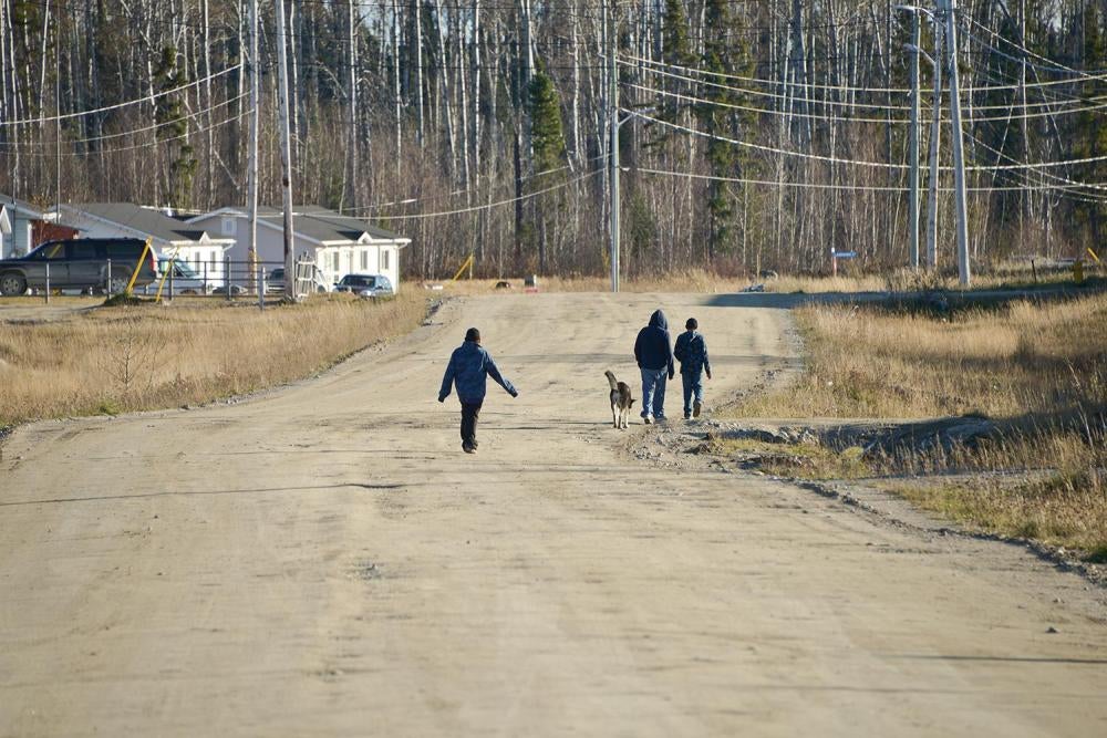 Youths walk along the road in Neskantaga First Nation, a remote community in Northern Ontario which has been on a boil water advisory since 1995. 