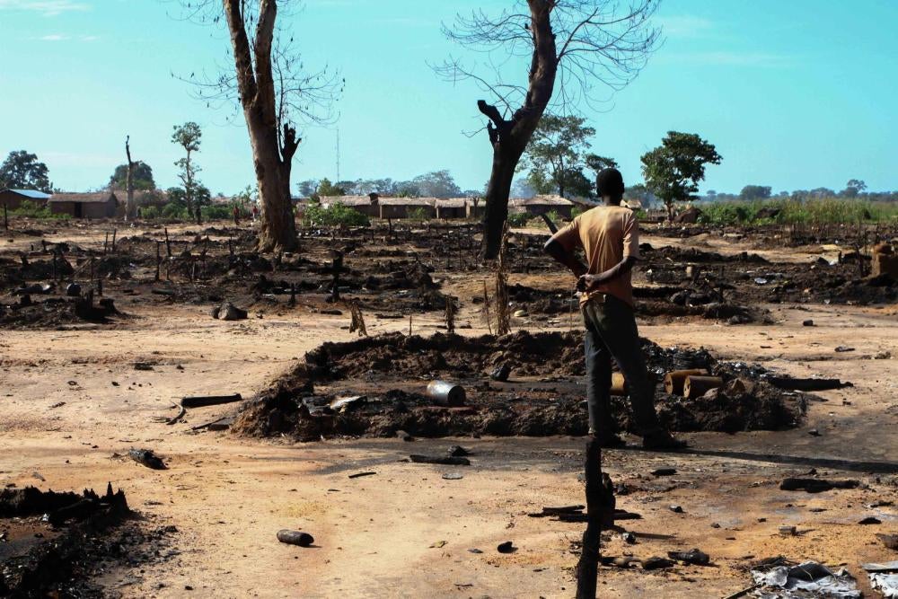 Un homme inspecte sa cabane incendiée le 12 octobre 2016 au camp de déplacés de l’Évêché, République centrafricaine. Les forces de la Séléka ont brûlé au moins 435 huttes dans le camp. 