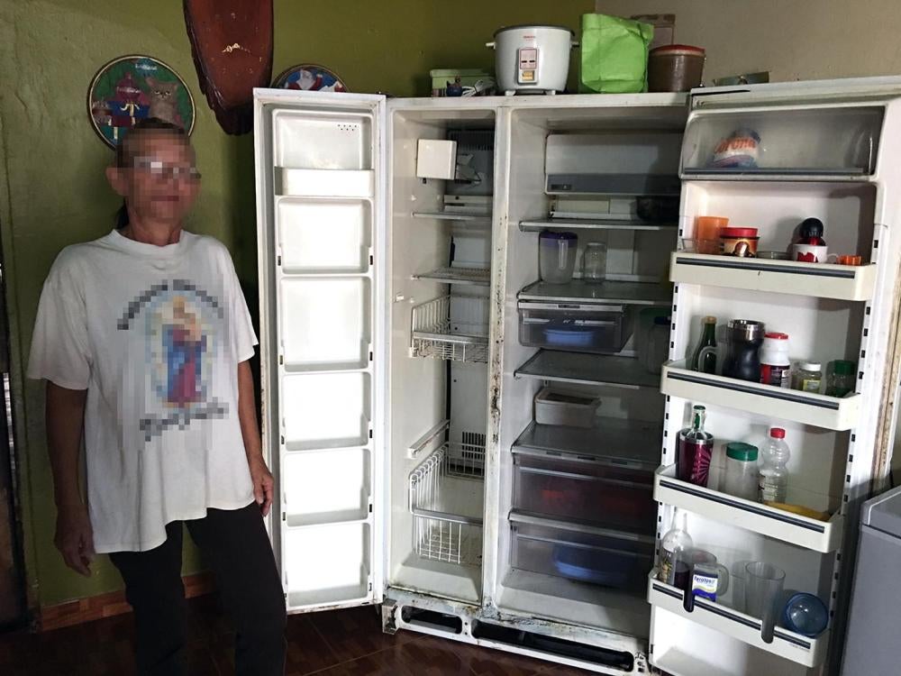 Una mujer muestra la disminución de los suministros de alimentos en su refrigerador en el estado de Zulia, junio de 2016. 