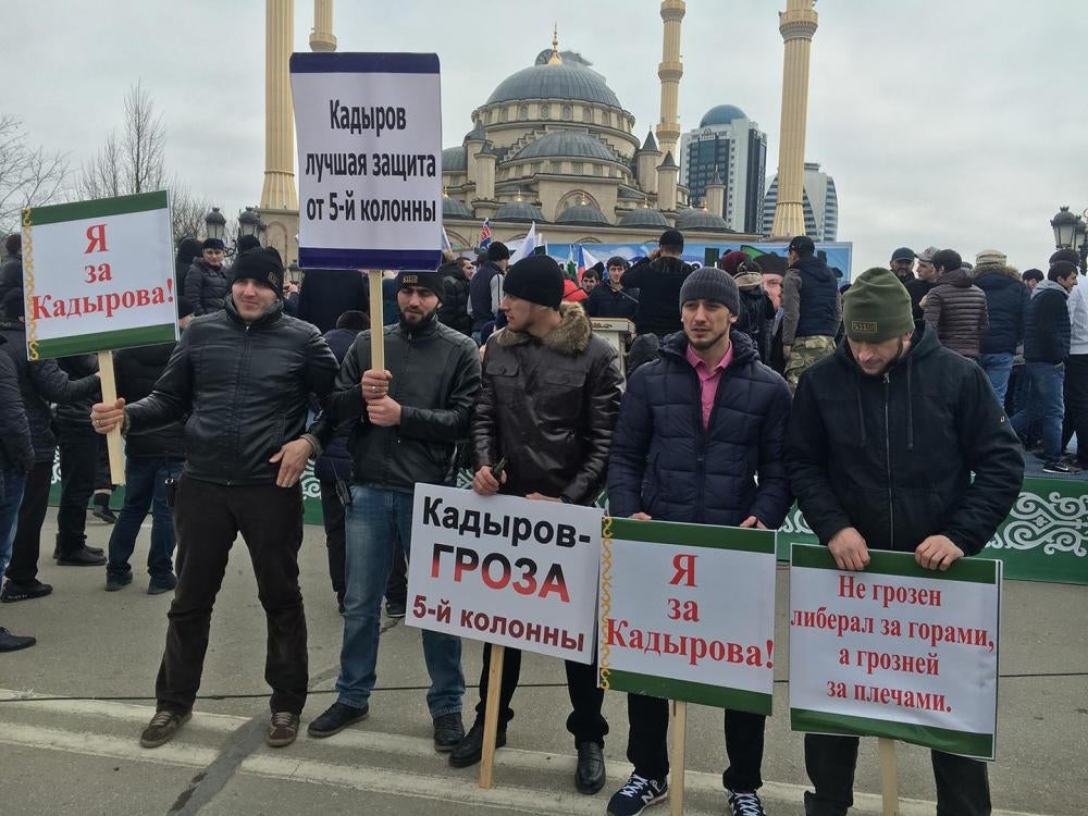 Мужчины держат плакаты с лозунгами «Я за Кадырова!» и «Кадыров – гроза 5-й колонны» на про-властном митинге, организованном в Грозном в январе 2016 г. 