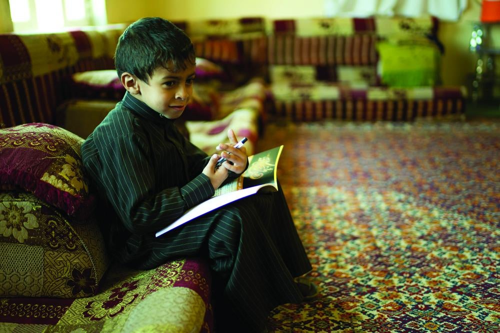 Habib, un garçon de sept ans atteint d’une infirmité motrice cérébrale, est assis avec ses livres dans sa maison de Sanaa. Il fréquentait auparavant un centre d’apprentissage pour enfants handicapés mais, lorsque la guerre a éclaté, le centre a fermé.