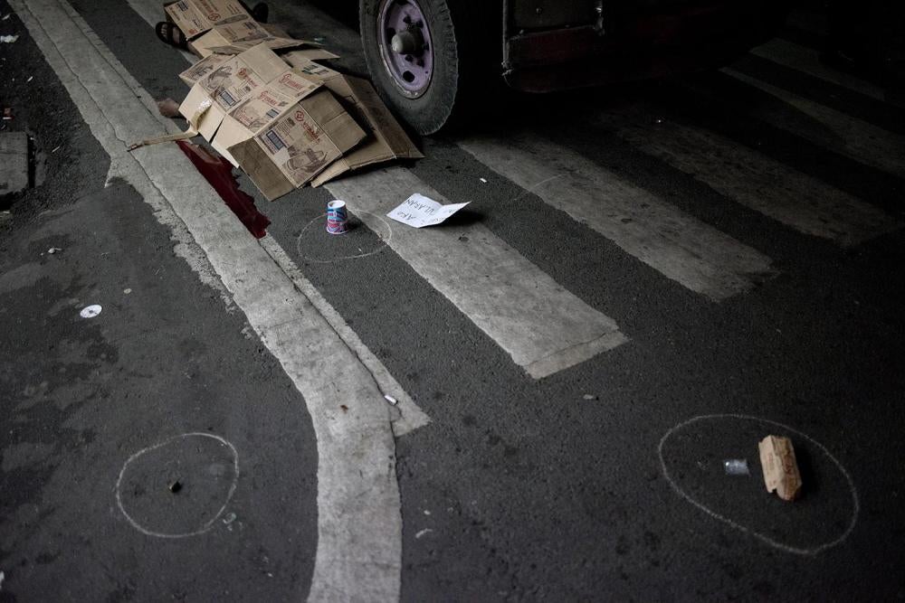 The body of Edwin Mendoza lies covered with cardboard boxes after he was shot dead by unidentified gunmen in front of a convenience store on Airport Road, Paranaque, Metro Manila. A sachet of shabu was allegedly found at the crime scene, October 18, 2016.