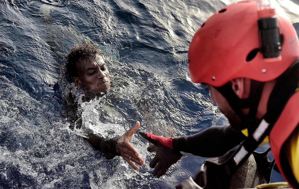A migrant is rescued from the mediteranean sea by a member of Proactiva Open Arms NGO some 20 nautical miles north of Libya on October 3, 2016. 