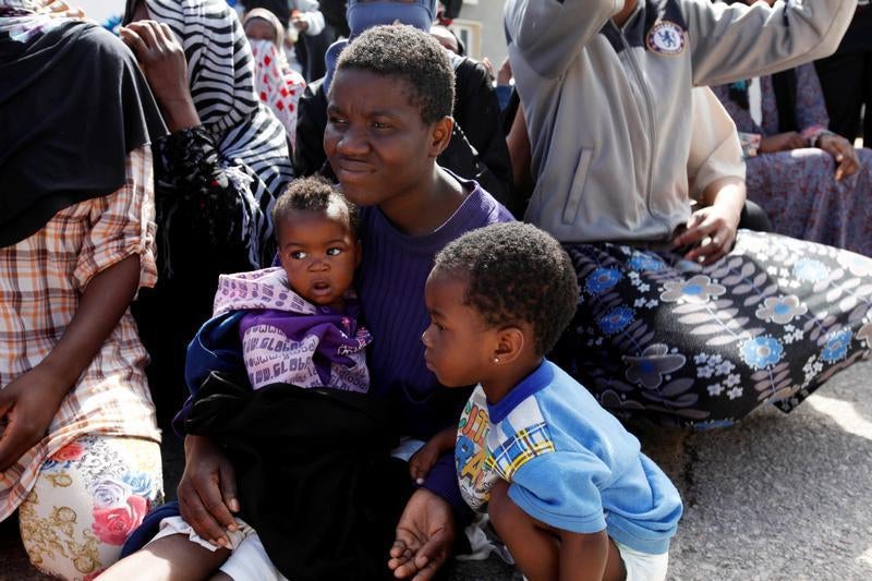 Un uomo seduto con i suoi figli in un centro di detenzione per migranti a Tripoli durante la visita di Martin Kobler, inviato special delle Nazioni Unite e capo della Missione di Supporto della Nazioni Unite in Libia e William Lacy Swing, direttore genera