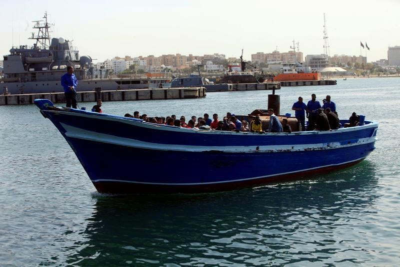 مركب خشبي يحمل مهاجرين وطالبي لجوء تم إنقاذهم في المياه الدولية من قبل حرس السواحل الليبي، أثناء وصوله إلى ميناء في طرابلس، ليبيا. © رويترز/إسماعيل زيتوني