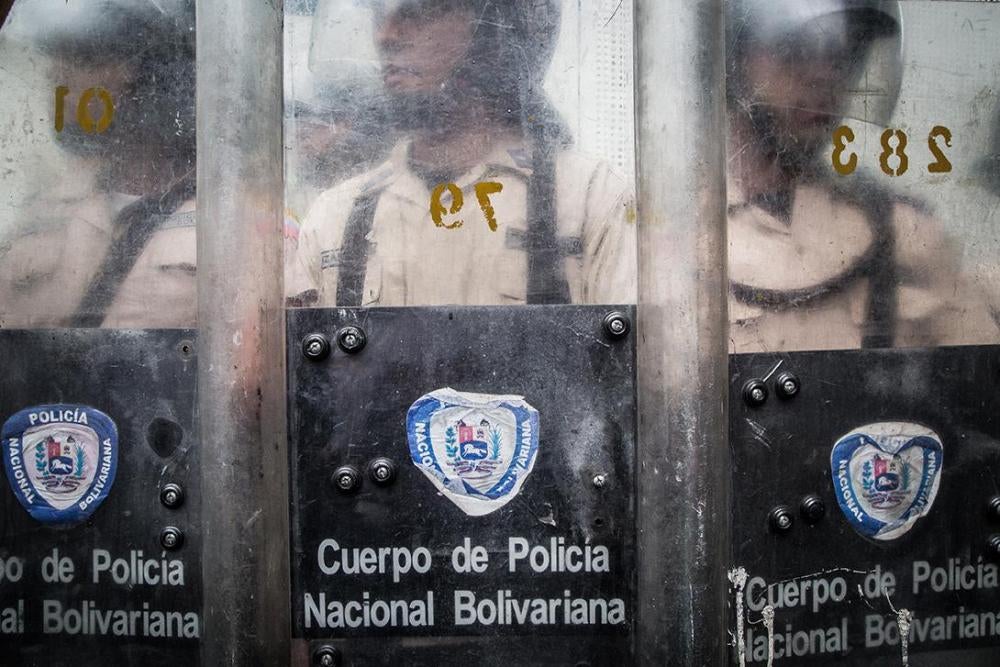 Officers of the Bolivarian National Police, behind their shields, block the street during an anti-government demonstration on Sabana Grande Boulevard, Caracas.