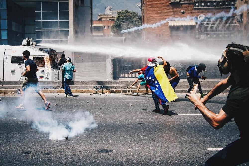 A riot police armored truck directs a water cannon at anti-government protesters in Caracas, Venezuela. April 6, 2017. 