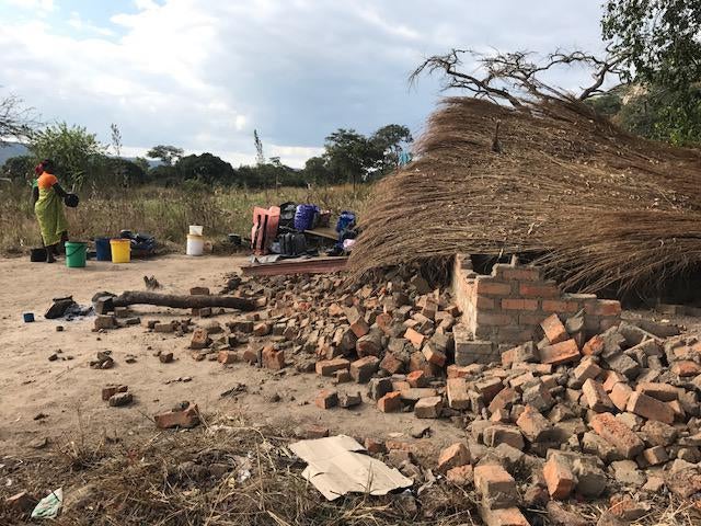 Two women clean pots and plates in front of the remains of their demolished house at Arnolds Farm, Mazowe. Anti-riot police, who claim the farm is owned by the First Family, demolished the house on May 9, 2017, despite two court orders prohibiting the dem