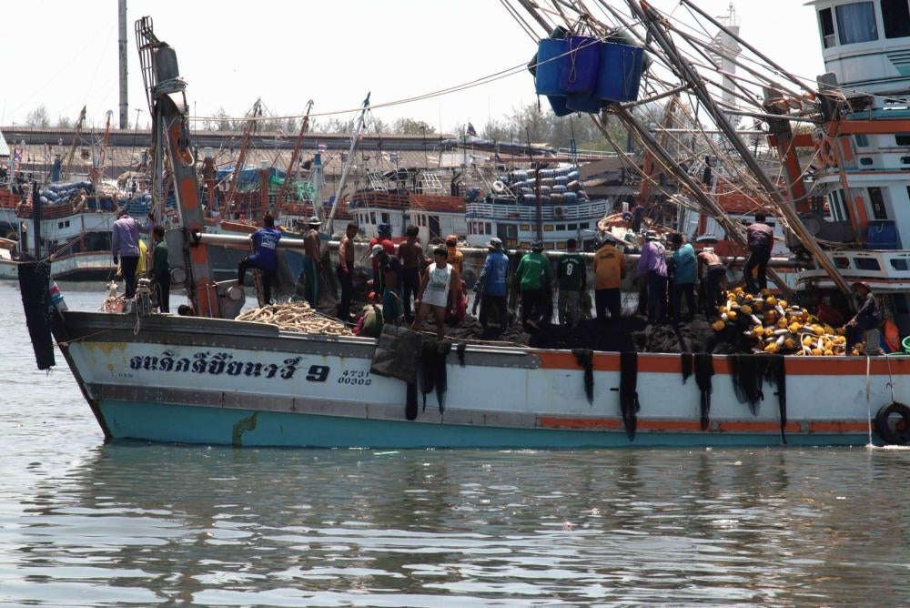Fishers prepare a seine net as a vessel returns to port in Ratsada, Phuket, March 10, 2016.