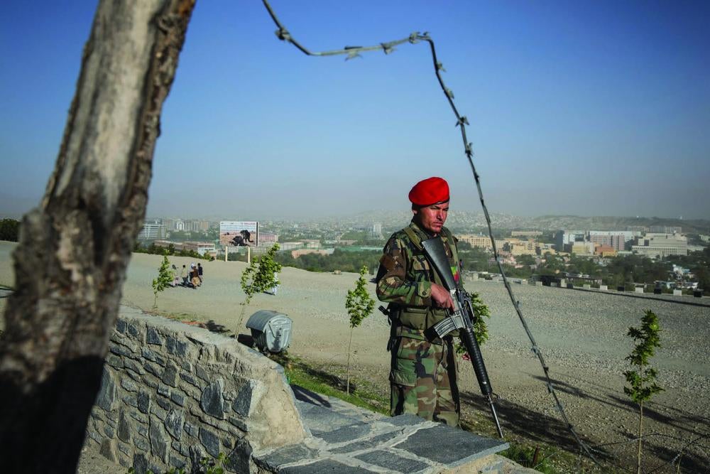 A member of Afghanistan’s security forces patrols on a hill overlooking Kabul.