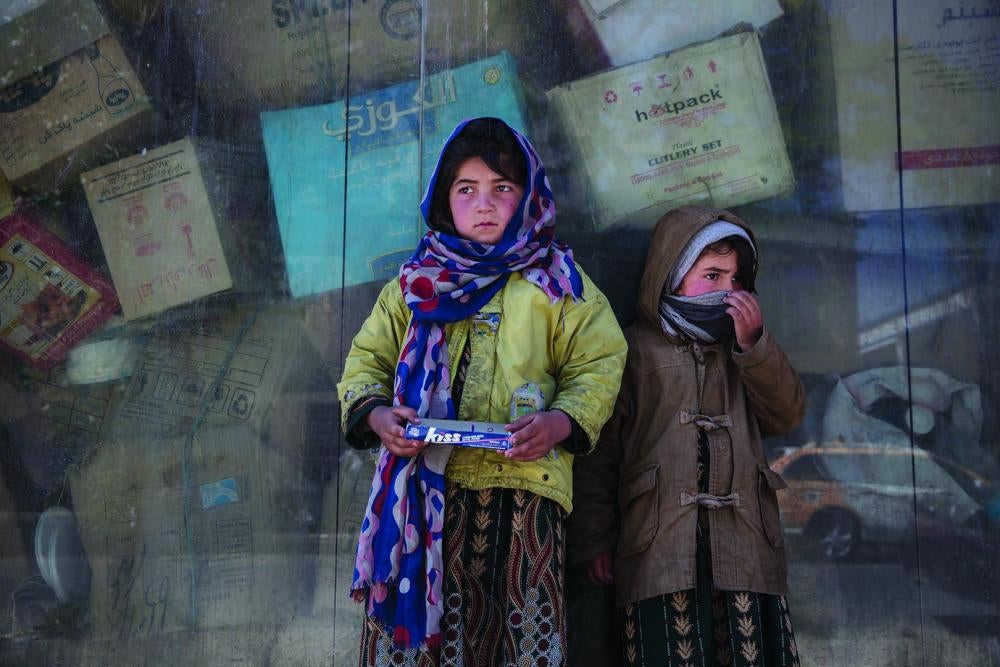 Two sisters, ages 9 and 5, work on the streets of Kabul selling chewing gum, earning about US$2 per day.