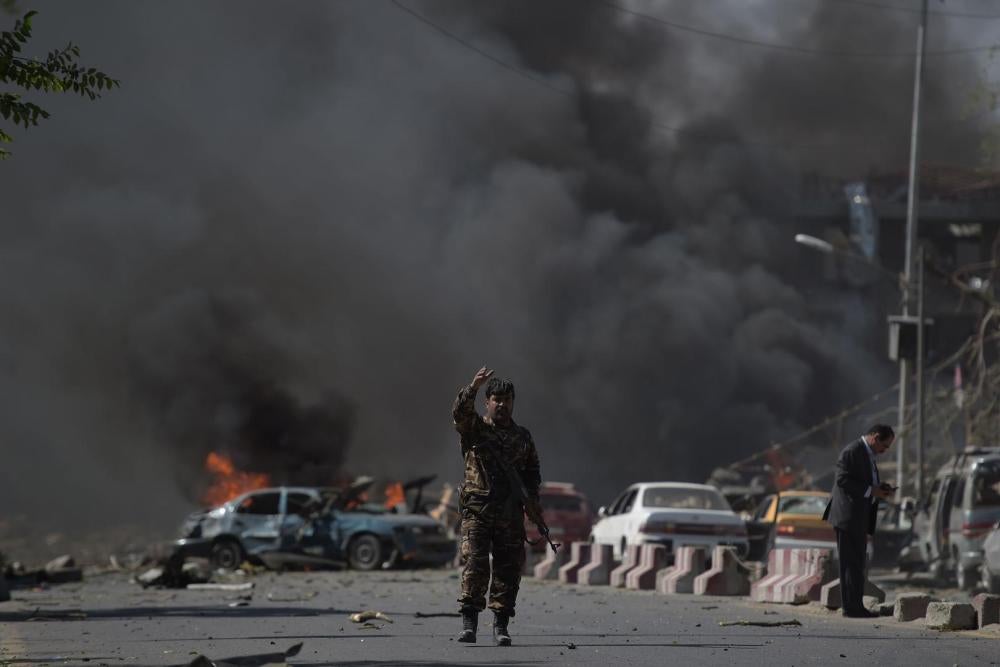 یک عضو نیروهای امنیتی افغانستان در محل حمله یک موتر بمب در‌ کابل ایستاده است ,31 مه 2017