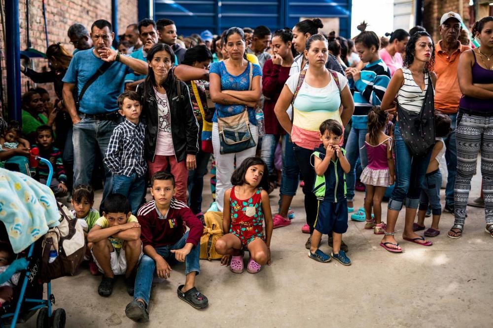 Venezuelans wait for breakfast at a soup kitchen administered by the diocese of Cucuta, Colombia, near the Venezuelan border on July 31, 2018. 